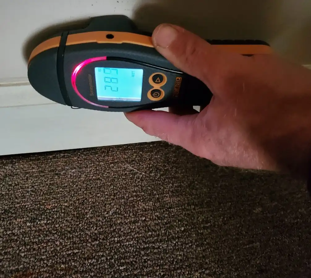 Moisture detection at baseboard during Storm Damage Restoration in Flint